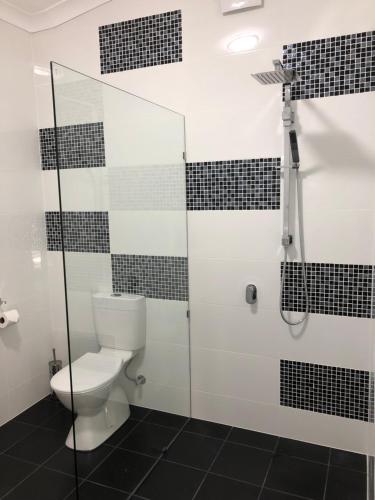 uma casa de banho com um WC e uma cabina de duche em vidro. em Amande Bed and Breakfast em McLaren Vale