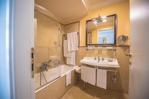 bagno con lavandino, vasca e specchio di Villa Daphne a Giardini Naxos