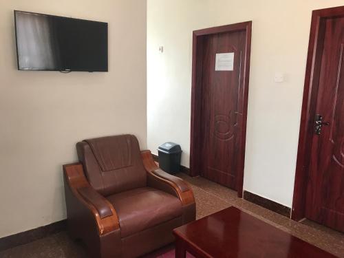 a living room with a chair and a television at Northern Rock Hotel in Mpika