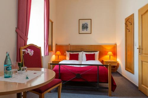 um quarto de hotel com uma cama, uma mesa e uma mesa em Wirtshaus zum Pferdemarkt em Saarburg