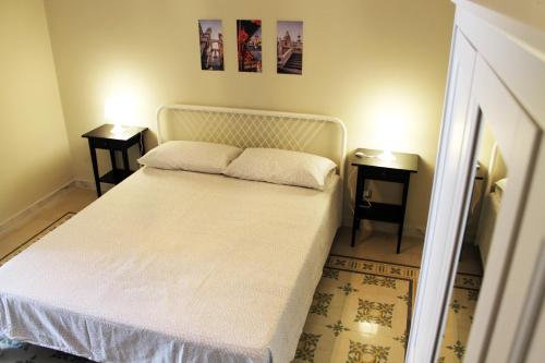 a bedroom with a white bed with two night stands at Casa Verdi, confortevole bilocale in centro, 1° p in Bagheria