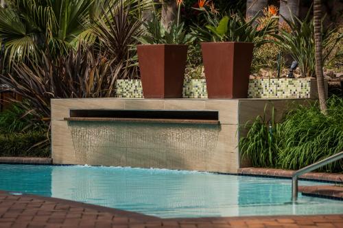 a swimming pool with potted plants on top of it at StayEasy Pretoria in Pretoria