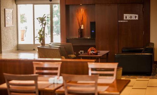 a restaurant with wooden tables and chairs and a bar at StayEasy Pretoria in Pretoria