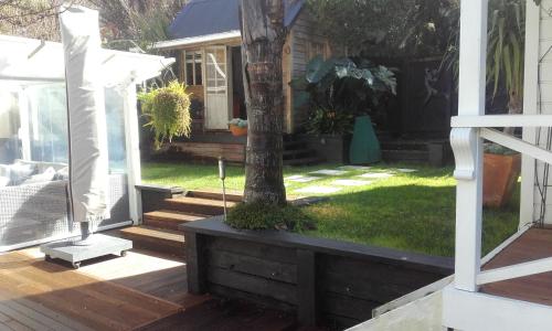 a porch with a tree and a house at Harbour View Cottage in Auckland