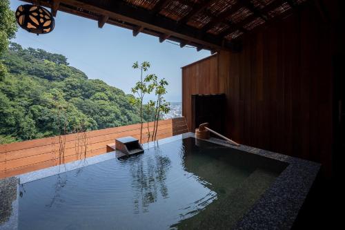 una stanza con una piscina d'acqua in un edificio di Watei Kazekomichi ad Atami