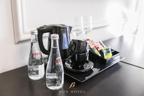 a counter with two bottles of water and a coffee maker at Bon Hotel in Dnipro