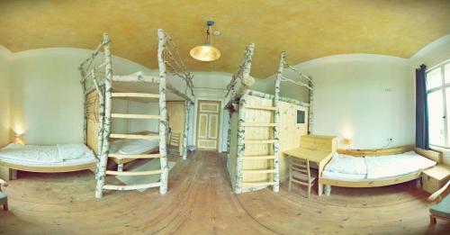 a room with three bunk beds and a desk at Spirit Lodge Leipzig in Leipzig