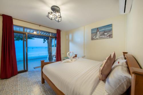 a bedroom with a large bed with a view of the ocean at Thong Nai Pan Beach Residence in Thong Nai Pan Yai