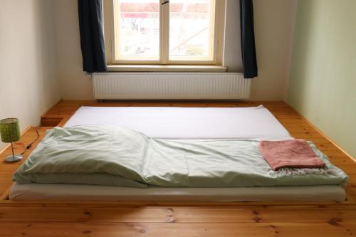 an unmade bed in a room with a window at Spirit Lodge Leipzig in Leipzig