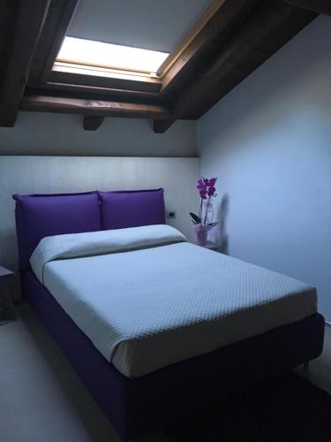 a bedroom with a large bed with purple pillows at sotto le stelle in Pieve di Teco