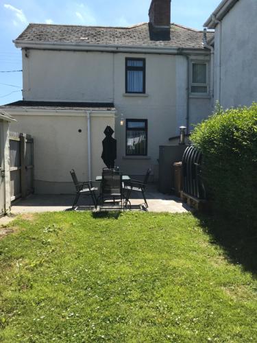 a house with two chairs and a table in the yard at Mountain View in Newcastle