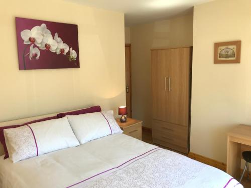 a bedroom with a white bed and a wooden cabinet at Mountain View in Newcastle