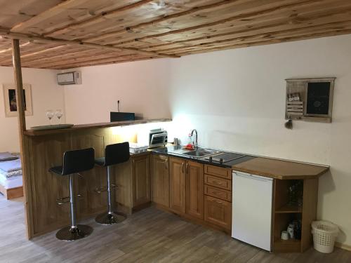 a kitchen with a counter and stools in a room at Apartma & savna Slapnik in Luče