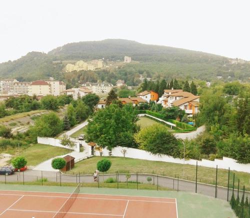 a tennis court with a town in the background at San Marco Villas in Kranevo