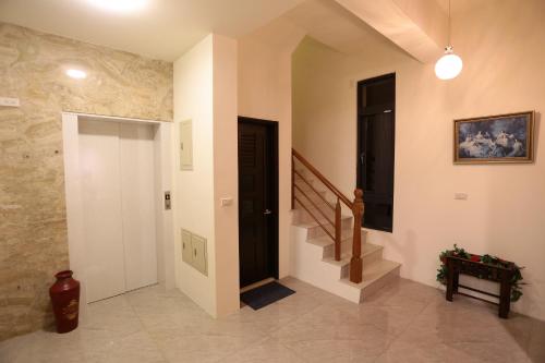 a hallway with a door and stairs in a house at 花蓮168電梯民宿-可包棟 in Jian