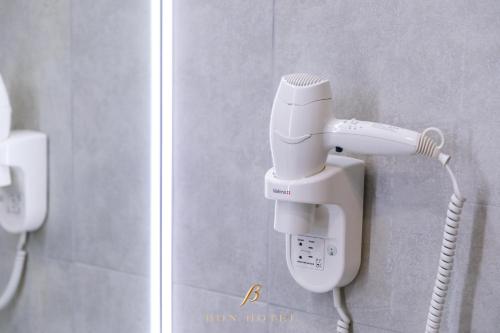 a hair dryer on the wall of a bathroom at Bon Hotel in Dnipro