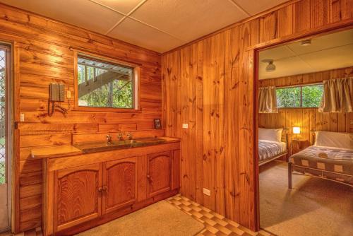 a bathroom with a sink and a bed in a room at Beachcroft in Coles Bay