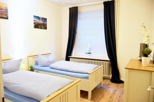 ein kleines Zimmer mit 2 Betten und einem Fenster in der Unterkunft Ferienapartment Süderstrasse in Borkum