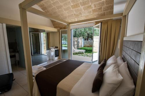 a bedroom with a large bed and a large window at Masseria Muntibianchi AgriResort Restaurant & SPA in Otranto