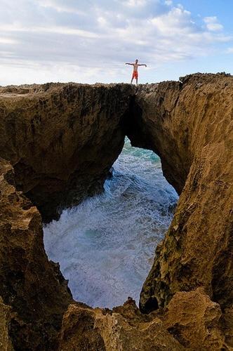 a person standing on top of a bridge over the water at Walk to the Beach 2Min, Cozy, Boutique, Pool, Palmeras Del Mar Isabela in Isabela