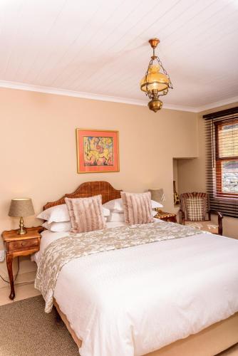 a bedroom with a large white bed and a chandelier at Bon Accord Farm Cottages in Montagu
