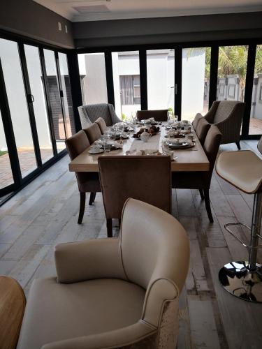 a dining room with a long table and chairs at Mmakgabo Boutique Lodge in Bela-Bela