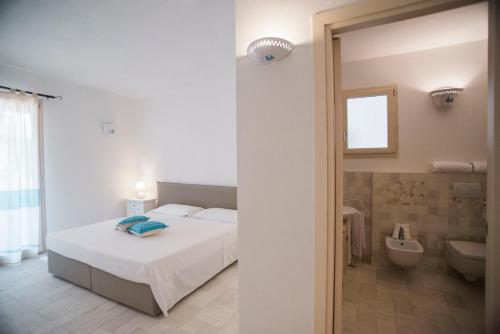 ポルト・チェルボにあるAllegroItalia Porto Cervoのベッドルーム1室(ベッド1台付)、バスルーム(トイレ付)