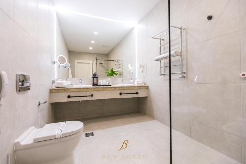 a bathroom with a toilet and a sink and a shower at Bon Hotel in Dnipro