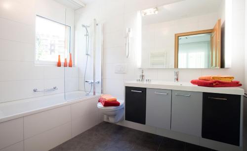 ein Badezimmer mit einem Waschbecken, einem WC und einem Spiegel in der Unterkunft Residence Golf C 21 in Leukerbad