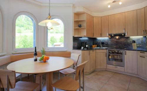 una cucina con tavolo in legno e una sala da pranzo di Residence Golf C 21 a Leukerbad