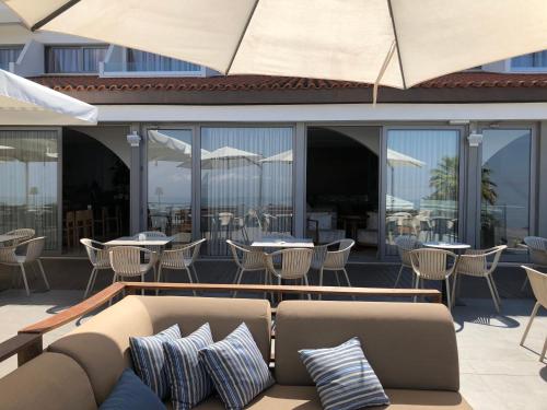 a patio with a couch and tables and chairs at Droushia Heights Hotel in Droushia