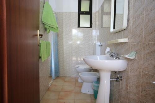 ein Bad mit einem Waschbecken und einem WC in der Unterkunft Hotel Club Poseidon in Stalettì