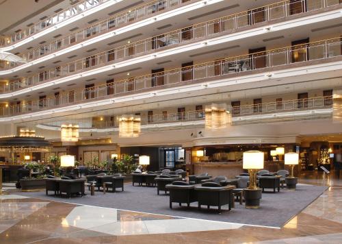 a large lobby with tables and chairs in a building at Maritim Airport Hotel Hannover in Hannover