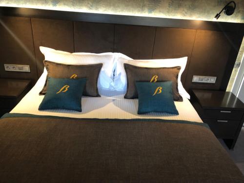 a bedroom with a large bed with two blue pillows at Bon Hotel in Dnipro