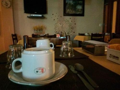 eine Tasse Kaffee auf einem Teller auf einem Tisch in der Unterkunft Hotel Resi San Bernardo in San Bernardo