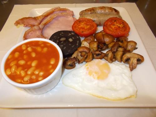 un plato de desayuno con huevos, setas y judías en Queens arms country inn, en Glossop