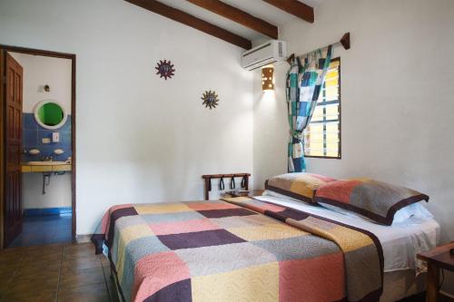 a bedroom with a bed with a colorful blanket on it at Villas Macondo in Tamarindo
