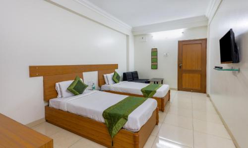 a hotel room with two beds and a television at Treebo Omni Palace in Indore
