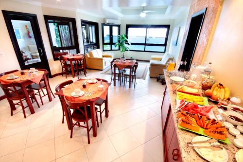 a dining room with tables and chairs in a restaurant at Mares do Sul Pousada in Garopaba