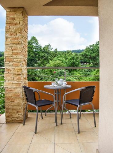 ein Tisch und Stühle auf einem Balkon mit Aussicht in der Unterkunft Apartmány RELAX Podhájska in Podhájska