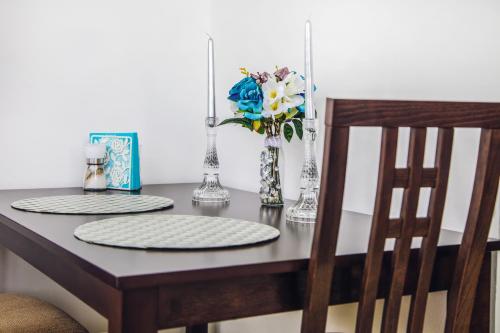 uma mesa com dois pratos e um vaso de flores em Apartmány RELAX Podhájska em Podhájska