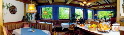 a dining room with two tables and two windows at Landhaus Gschaiderhof in Puchberg am Schneeberg