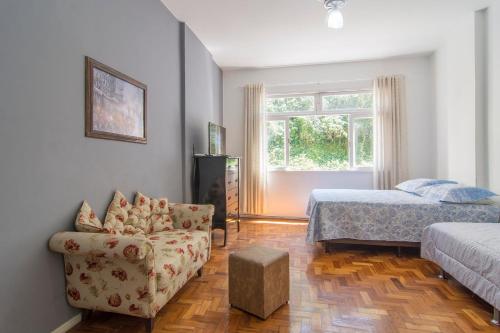 a bedroom with a bed and a couch and a chair at FLAT 201 in Petrópolis