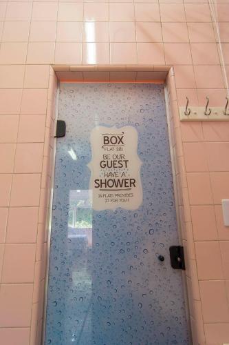 a shower with a sign on the door of a shower stall at FLAT 201 in Petrópolis