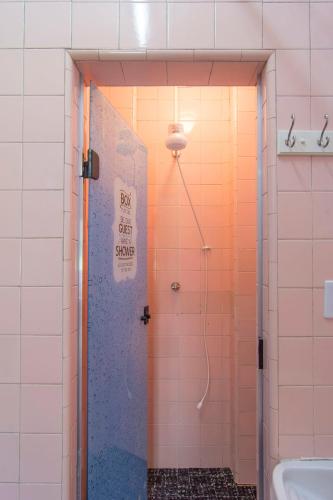 a bathroom with a shower with a blue door at FLAT 201 in Petrópolis