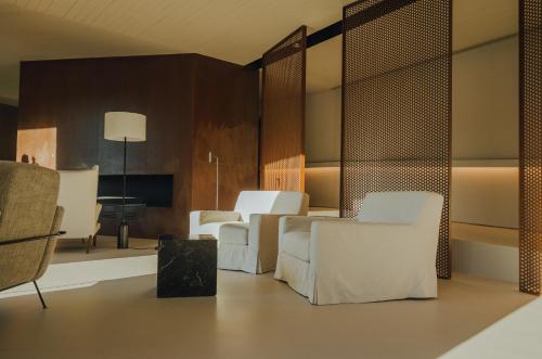 a living room with white chairs and a table at Octant Douro in Castelo de Paiva