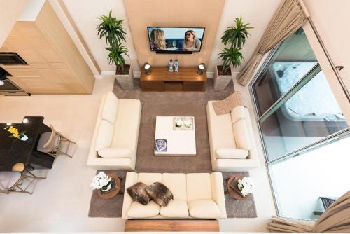 an overhead view of a living room with couches and a tv at Magic Village Yards Trademark Collection by Wyndham in Orlando