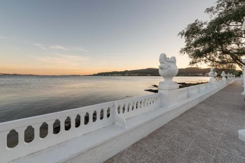 a white fence next to a body of water at Eurostars Isla de La Toja in Isla de la Toja