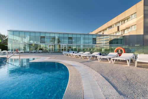 a building with a swimming pool in front of a building at Eurostars Isla de La Toja in Isla de la Toja