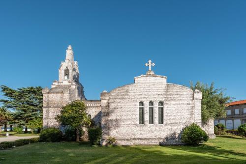 an old church with a cross on top of it at Eurostars Isla de La Toja in Isla de la Toja